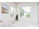 Bright bathroom featuring a soaking tub beneath windows, complemented by a decorative art piece at 4913 Stockton Way, Durham, NC 27707