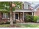 Close up of a brick home's front door with a small porch and beautiful landscaping at 4913 Stockton Way, Durham, NC 27707