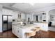 Open concept kitchen with granite countertops, white cabinets, stainless appliances, island with seating, and hardwood floors at 4913 Stockton Way, Durham, NC 27707