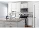 Bright kitchen features white cabinets, granite countertops, stainless steel appliances, and a kitchen island at 4913 Stockton Way, Durham, NC 27707