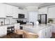 Bright kitchen with white cabinets, granite countertops, stainless steel appliances, and island with seating at 4913 Stockton Way, Durham, NC 27707