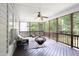 Relaxing screened porch with wooded backyard view, ceiling fan, and stylish outdoor seating at 4913 Stockton Way, Durham, NC 27707