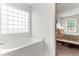 Bright bathroom featuring a luxurious bathtub with a unique glass block window for natural light and privacy at 50 Waterford Dr, Angier, NC 27501