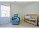 Cozy Bedroom room showcasing a comfortable chair and wooden crib near a window at 50 Waterford Dr, Angier, NC 27501