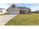 Charming single-Gathering home featuring an attached two-car garage and inviting covered front porch with rocking chairs at 50 Waterford Dr, Angier, NC 27501