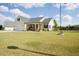 Charming home with a spacious front yard, covered porch, and American flag at 50 Waterford Dr, Angier, NC 27501