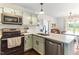 Modern kitchen featuring stainless steel appliances, light green cabinets, and stylish countertops at 50 Waterford Dr, Angier, NC 27501