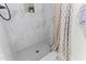 Elegant walk-in shower with white marble-look tile, a niche, and stylish fixtures, offering a spa-like experience at 50 Waterford Dr, Angier, NC 27501