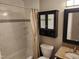 Cozy bathroom featuring tiled walls, granite countertop, a shower curtain and vanity storage at 501 Samara St, Apex, NC 27502