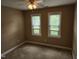 Neutral bedroom with plush carpet, base trim and natural light from two windows and ceiling fan at 501 Samara St, Apex, NC 27502