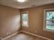 Neutral bedroom with plush carpet, base trim and natural light from two windows at 501 Samara St, Apex, NC 27502