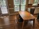 Light-filled dining room features a wooden table, four chairs, and multiple windows overlooking the yard at 501 Samara St, Apex, NC 27502