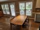 Light-filled dining room features a wooden table, four chairs, and multiple windows overlooking the yard at 501 Samara St, Apex, NC 27502