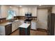 Bright kitchen features stainless steel appliances, white cabinets and center island with stone countertops at 501 Samara St, Apex, NC 27502
