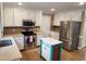 Bright kitchen features stainless steel appliances, white cabinets and center island with stone countertops at 501 Samara St, Apex, NC 27502