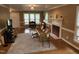 Cozy living room featuring leather couch, fireplace with intricate paneling, and light from large windows at 501 Samara St, Apex, NC 27502