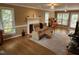 Cozy living room featuring leather couch, fireplace with intricate paneling, and light from large windows at 501 Samara St, Apex, NC 27502