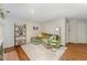 Living room showcasing a green couch, fireplace, bookcase and decor with hardwood floors at 503 Gooseneck Drive # B4, Cary, NC 27513