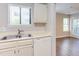 Kitchen with stainless steel sink, white dishwasher, and view into a sunlit living area at 600 Audubon Lake Dr # 6B13, Durham, NC 27713