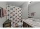 Charming bathroom featuring a patterned shower curtain, a neutral color scheme, and functional storage at 609 Woodson Dr, Clayton, NC 27527