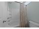 Bright bathroom featuring a shower-tub combo with tiled walls and a decorative shower curtain at 609 Woodson Dr, Clayton, NC 27527
