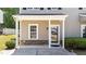 Inviting front porch featuring classic columns, stone accents, and a window with natural light, enhanced by manicured landscaping at 609 Woodson Dr, Clayton, NC 27527