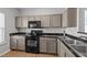 Stylish kitchen with black appliances, sleek countertops, modern backsplash and wood look floors create a great cooking space at 609 Woodson Dr, Clayton, NC 27527