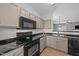 Modern kitchen with black appliances, granite countertops, ample cabinet space, and an open view to the living area at 609 Woodson Dr, Clayton, NC 27527