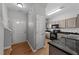 Bright entrance and kitchen featuring sleek black appliances, granite countertops, and wood-look flooring for modern appeal at 609 Woodson Dr, Clayton, NC 27527