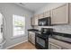 Well-lit kitchen featuring stainless steel appliances, granite countertops, ample cabinet space, and sleek flooring at 609 Woodson Dr, Clayton, NC 27527