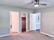 Bedroom with neutral walls, ceiling fan, and several doorways visible at 6579 Sidney Cottrell Rd, Oxford, NC 27565