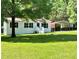 Exterior shot featuring well-maintained lawn, a metal carport, and mature shade trees at 6579 Sidney Cottrell Rd, Oxford, NC 27565