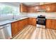 Well-equipped kitchen with wood cabinets, granite countertops, and stainless steel dishwasher and oven at 6579 Sidney Cottrell Rd, Oxford, NC 27565