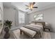 Comfortable bedroom featuring neutral tones, ceiling fan, and bench seating at the foot of the bed at 700 Finsbury St # 105, Durham, NC 27703