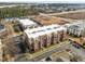 Aerial view of a four-story brick apartment building with balconies at 700 Finsbury St # 105, Durham, NC 27703