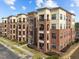 Brick apartment building featuring balconies, light-colored accents, sidewalk, and manicured lawn at 700 Finsbury St # 105, Durham, NC 27703