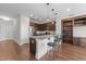 Open concept kitchen with stainless steel appliances, island with bar seating, and hardwood floors at 700 Finsbury St # 105, Durham, NC 27703