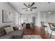 Open-concept dining and living room combination featuring hardwood floors, ceiling fan, and plenty of natural light at 700 Finsbury St # 105, Durham, NC 27703