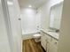 Bright bathroom featuring wood-look flooring, granite countertop, white fixtures and shower-tub combo at 71 Earnest Way, Kenly, NC 27542