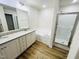 Stylish bathroom with double vanity, soaking tub, a glass-enclosed shower, and wood-look flooring at 71 Earnest Way, Kenly, NC 27542