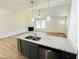 Open kitchen with stone countertops and island, flowing to the living area at 71 Earnest Way, Kenly, NC 27542