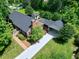 Aerial view of home features large driveway, well-manicured lawn, and mature trees at 7204 Bellweather N Ct, Raleigh, NC 27615