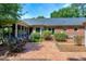 Brick patio surrounded by manicured landscaping and lush greenery, offering a serene outdoor living space at 7204 Bellweather N Ct, Raleigh, NC 27615