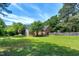Green backyard with lawn, a small shed, and privacy fence at 7204 Bellweather N Ct, Raleigh, NC 27615