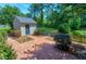 View of backyard with a shed and patio, surrounded by lush green trees at 7204 Bellweather N Ct, Raleigh, NC 27615
