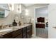 Bathroom featuring a double sink vanity with granite countertop and access to the main bedroom at 7204 Bellweather N Ct, Raleigh, NC 27615