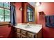 A bathroom featuring a vanity, framed mirror, and patterned wallpaper at 7204 Bellweather N Ct, Raleigh, NC 27615