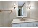 A bright bathroom with patterned wallpaper, a vanity, and neutral countertops at 7204 Bellweather N Ct, Raleigh, NC 27615