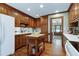 Traditional kitchen with white appliances, hardwood floors, and a center island provides a functional cooking space at 7204 Bellweather N Ct, Raleigh, NC 27615