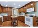 Well-appointed kitchen with custom wood cabinetry, white countertops, and hardwood floors offers abundant storage at 7204 Bellweather N Ct, Raleigh, NC 27615
